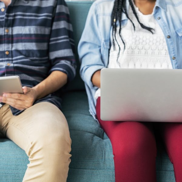 woman typing on laptop, man writing in notebook