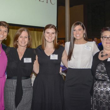 five women dressed up, smiling