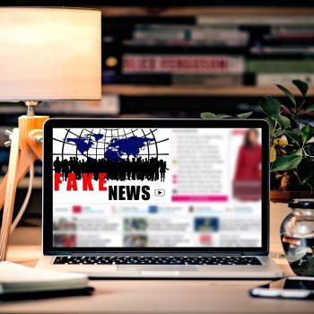 laptop on a desk with fake news on screen