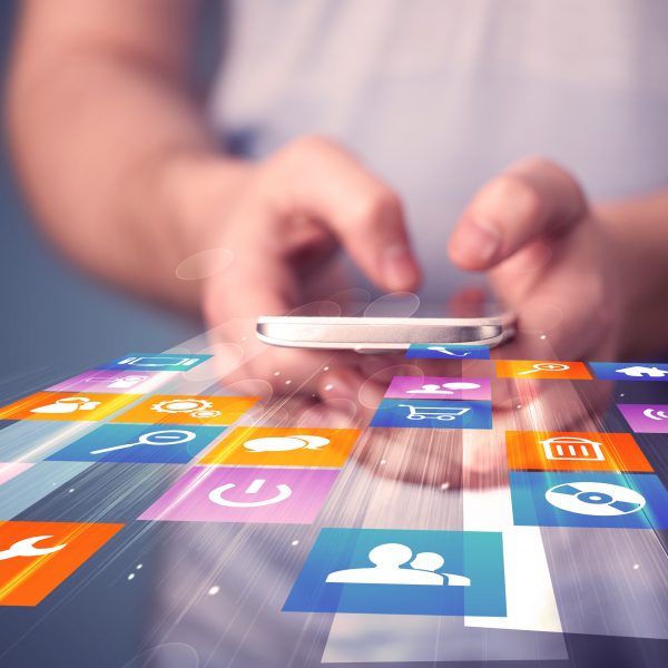 person holding smartphone with colorful application icons coming out