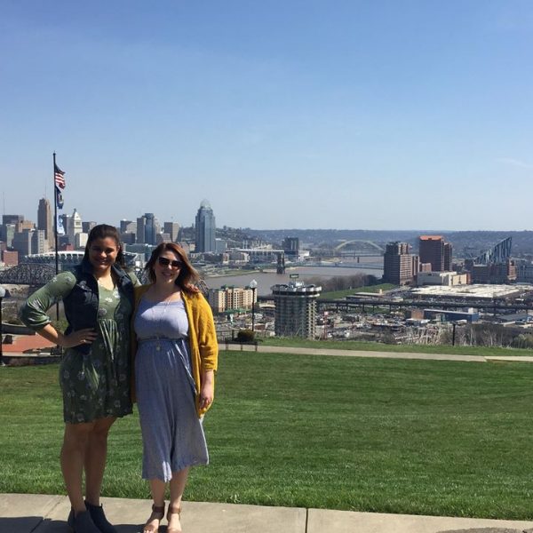 two women smiling with Cincinnati skyline in the background