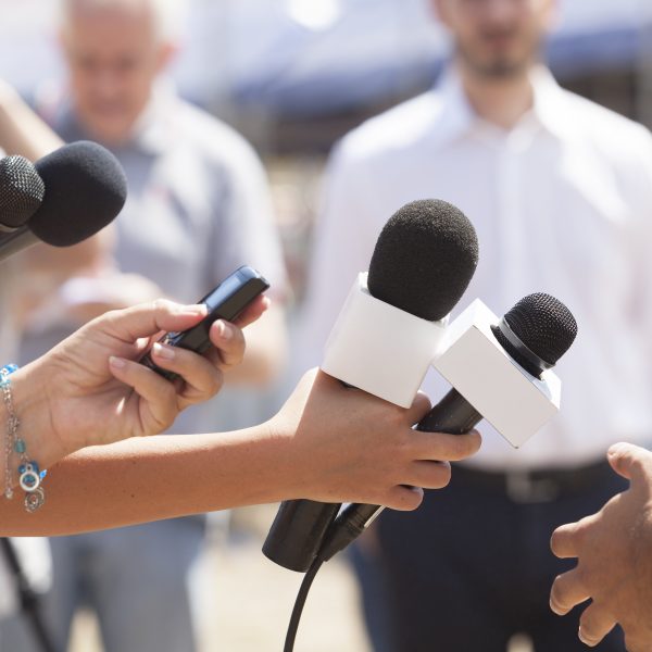 reporters with microphones out