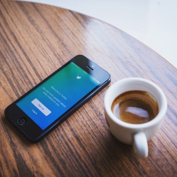 photo of coffee cup and iphone on table