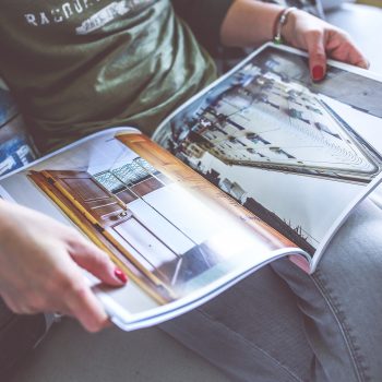 Person in a chair looking at a magazine.