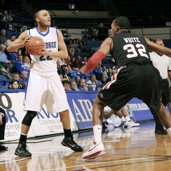 Two guys playing basketball in front of crowd