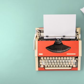 red typewriter on teal background