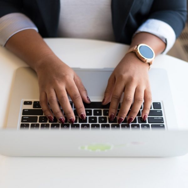 Close up of woman's hands typing on a laptop