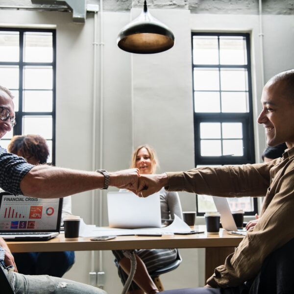 CoWorkers fist bumping each other while sitting down