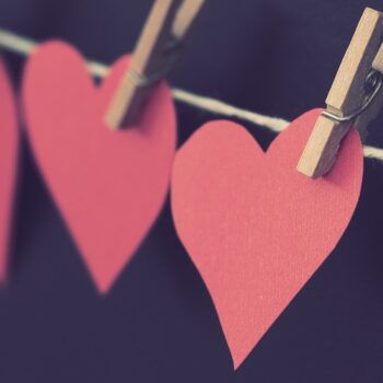 construction paper hearts attached to a string by clothespins