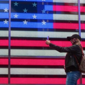 Woman taking selfie in front of the American flag