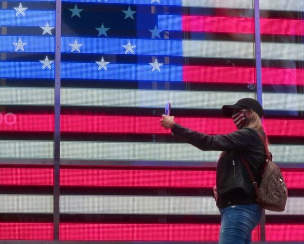 Woman taking selfie in front of the American flag