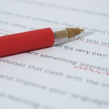 A paper marked in red pen with proofreading marks