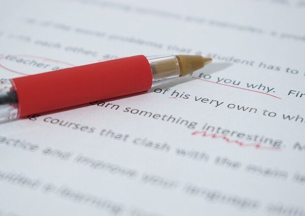 A paper marked in red pen with proofreading marks