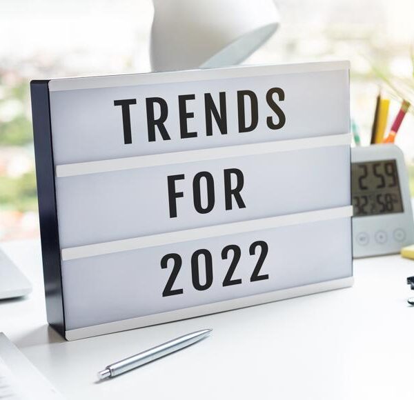 Desk with computer and sign that reads "Trends for 2022"