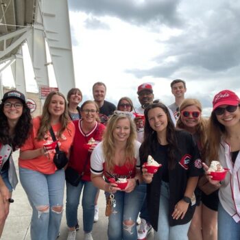 The Scooter Media team posing for a photo at a Reds game as part of a company culture outing.