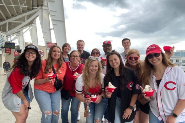 The Scooter Media team posing for a photo at a Reds game as part of a company culture outing.