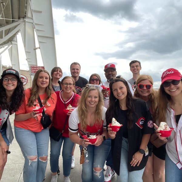 The Scooter Media team posing for a photo at a Reds game as part of a company culture outing.