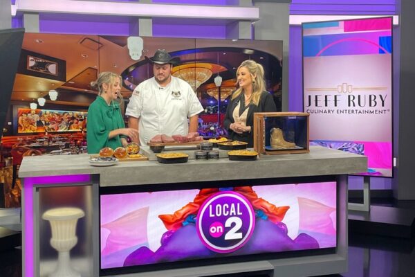 Members of the Jeff Ruby Culinary Entertainment team participating in a live interview in a news studio.