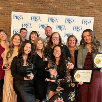 The Scooter Media team posing for a photo holding awards at Cincinnati PRSA's 2024 Blacksmith Awards.