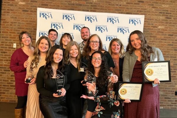 The Scooter Media team posing for a photo holding awards at Cincinnati PRSA's 2024 Blacksmith Awards.