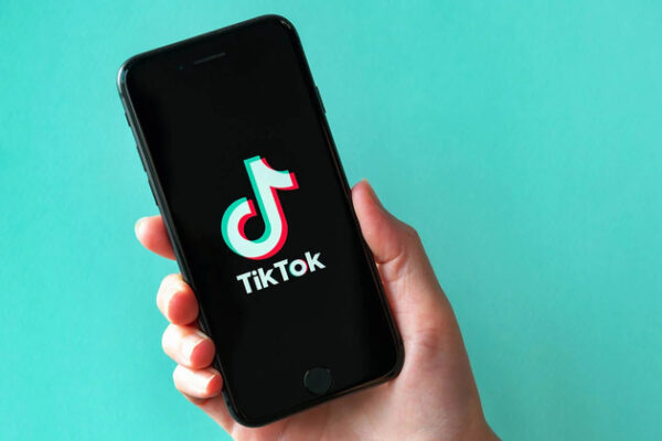 A smartphone displaying the TikTok logo set against a teal backdrop.