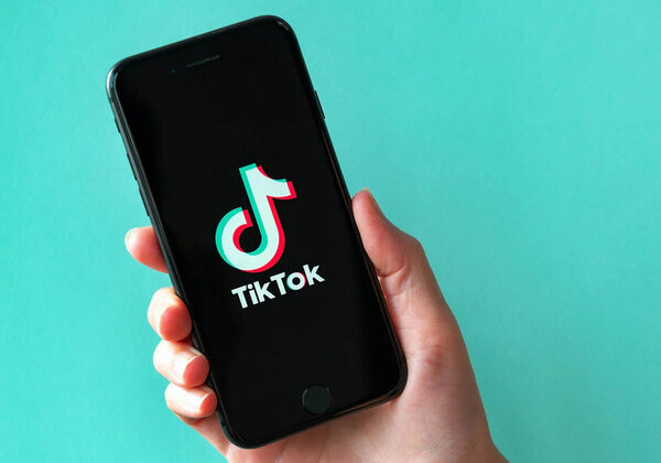 A smartphone displaying the TikTok logo set against a teal backdrop.